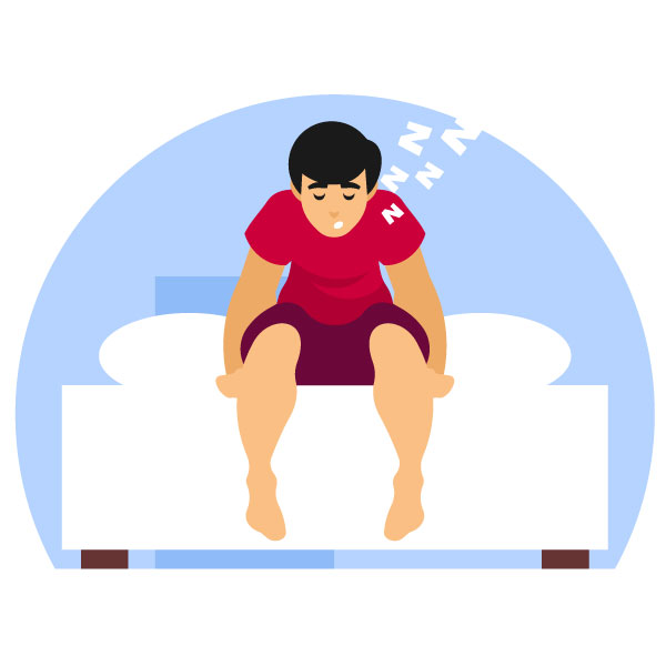 Verschlafener Mann sitzt auf seinem Bett